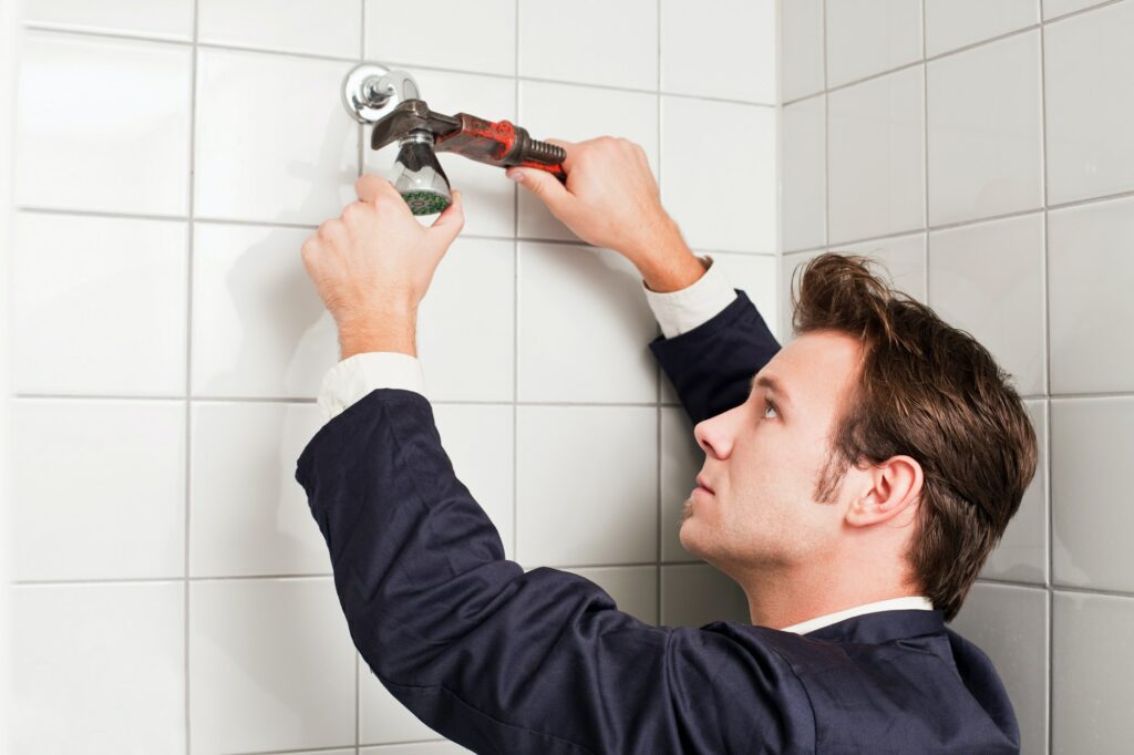 Plumber fixing shower head